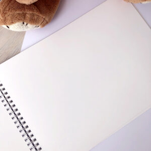 Ukázka prázdné strany miminkovského alba „Moje první album – Duha“ s kvalitním pevným papírem a kroužkovou vazbou.